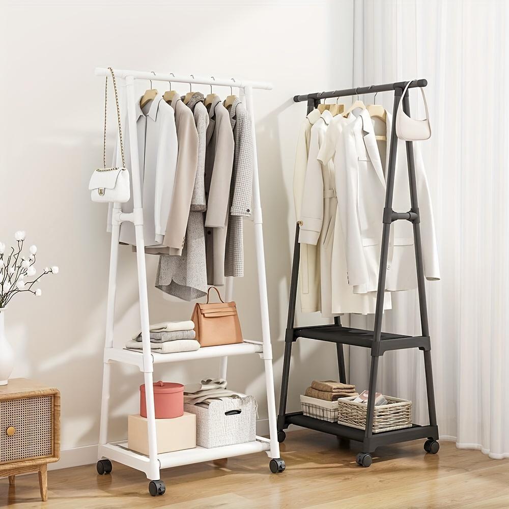 Two clothing racks with clothes and shelves against a white wall.