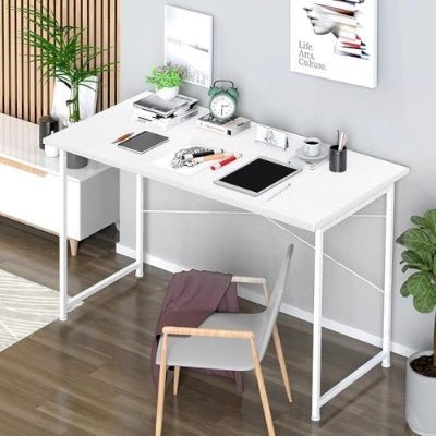 White L-shaped desk with office supplies in a room with plants and a chair.