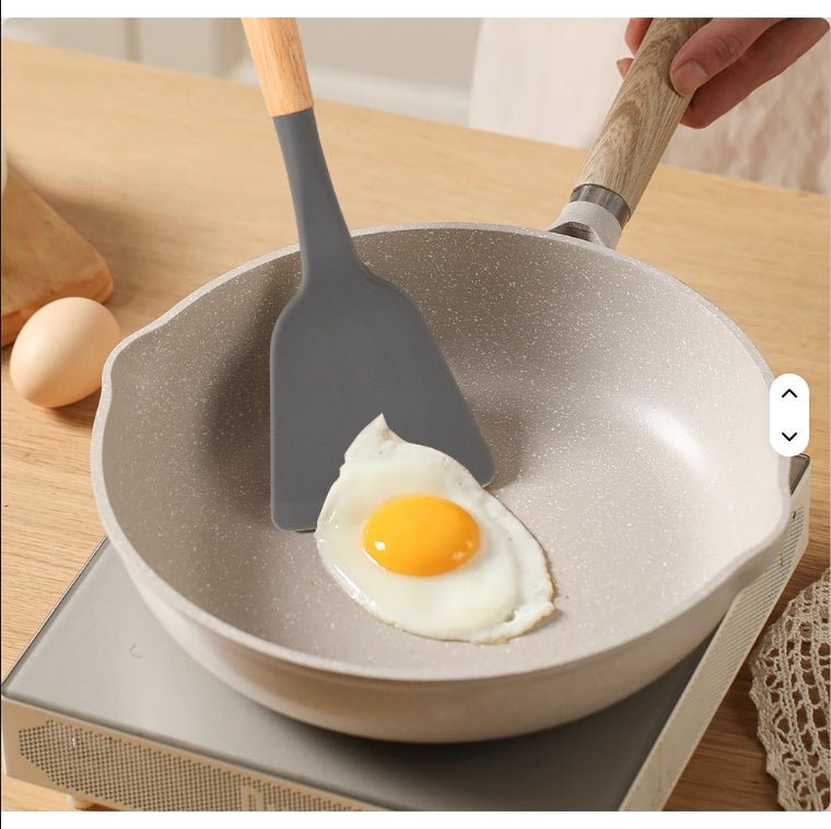 Fried egg in a pan with a spatula on a wooden table