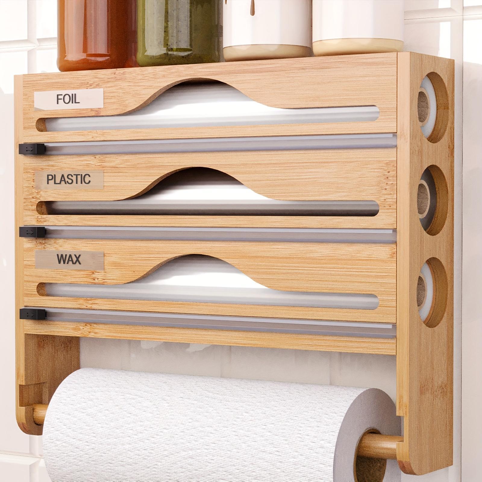 Wooden wall-mounted kitchen roll holder with labeled compartments for foil, plastic, and wax paper.