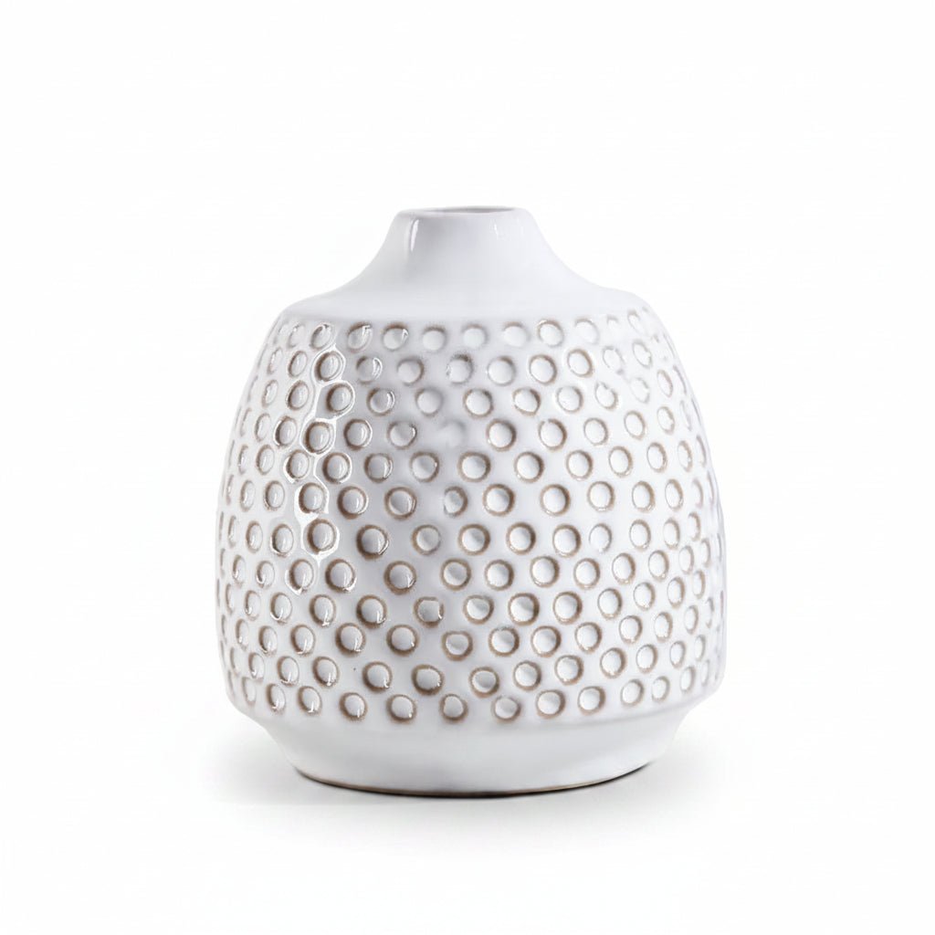 A white ceramic vase with a textured, dimpled surface pattern, photographed against a seamless white background.