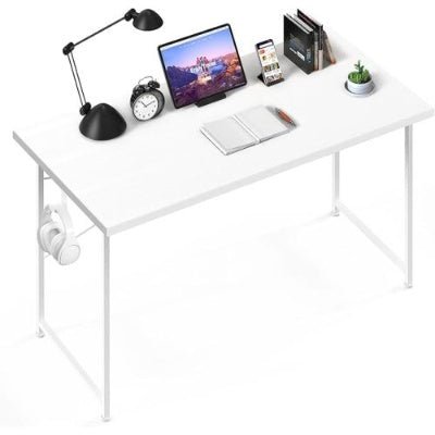White desk with laptop, lamp, and other items on a white background
