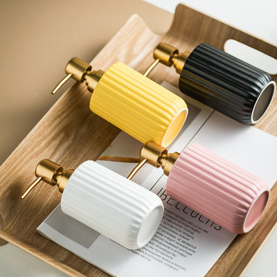 Set of four colorful ribbed cups on a wooden tray with an open book underneath.