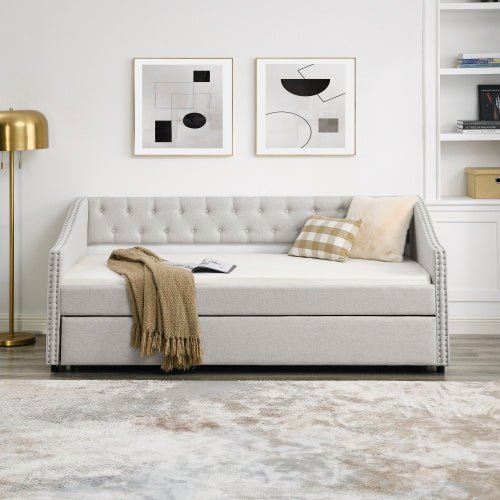 Gray upholstered sofa bed in a modern living room with abstract art and a lamp.