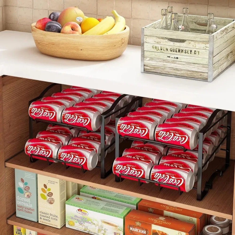 Coca-Cola cans in a metal organizer on a kitchen shelf with fruit and a wooden crate in the background.