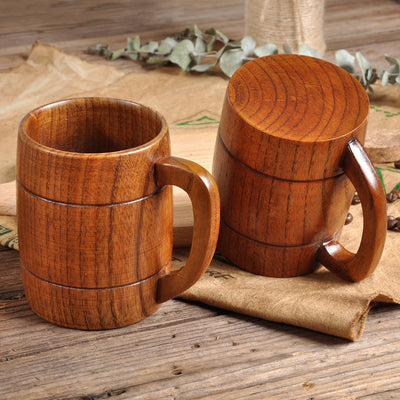 Two wooden mugs with lids on a rustic wooden surface.