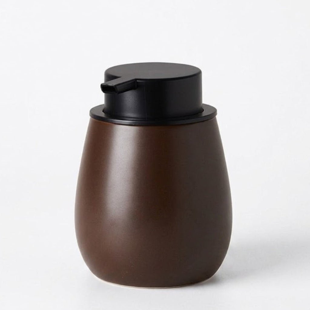 Brown ceramic soap dispenser with black pump on a white background