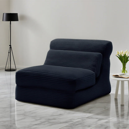 Modern navy blue lounge chair in a minimalistic room with a lamp and small table.