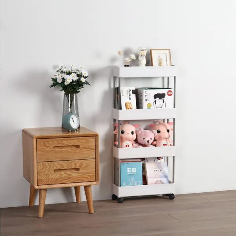 Wooden nightstand with a vase of flowers and a white storage cart with toys and books on a light gray background.