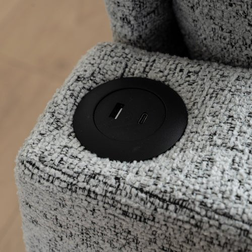 Close-up of a textured gray electronic device with a black circular control panel.