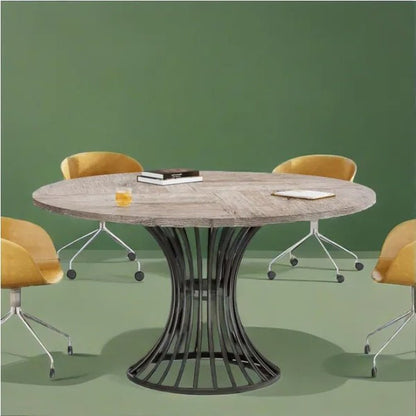 Round wooden table with a black metal base in a room with green walls and yellow chairs.