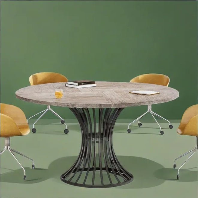 Round wooden table with a black metal base in a room with green walls and yellow chairs.