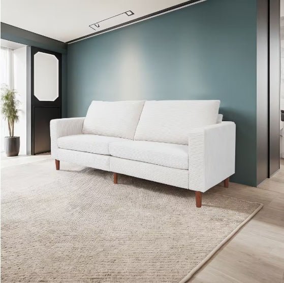 White sofa in a modern room with a green wall and large windows.