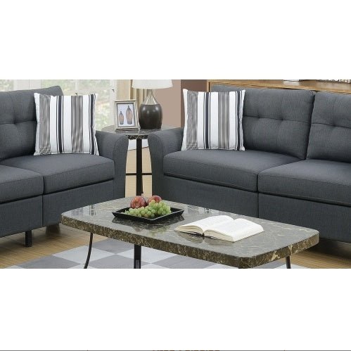 Gray sectional sofa with marble coffee table and decorative items in a living room setting.