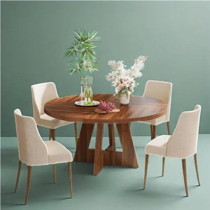 Dining table set with four chairs against a green wall