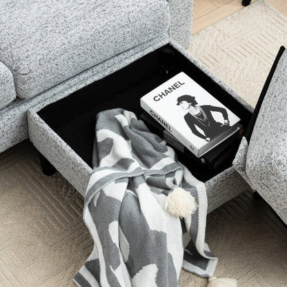 Gray and white patterned blanket draped over a coffee table with a Chanel book on top.