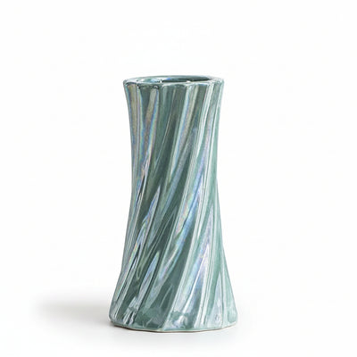 A small iridescent ceramic vase with a flared top and twisted, ribbed sides, shown on a clean white surface. Text in the upper left reads 'Diameter 6.