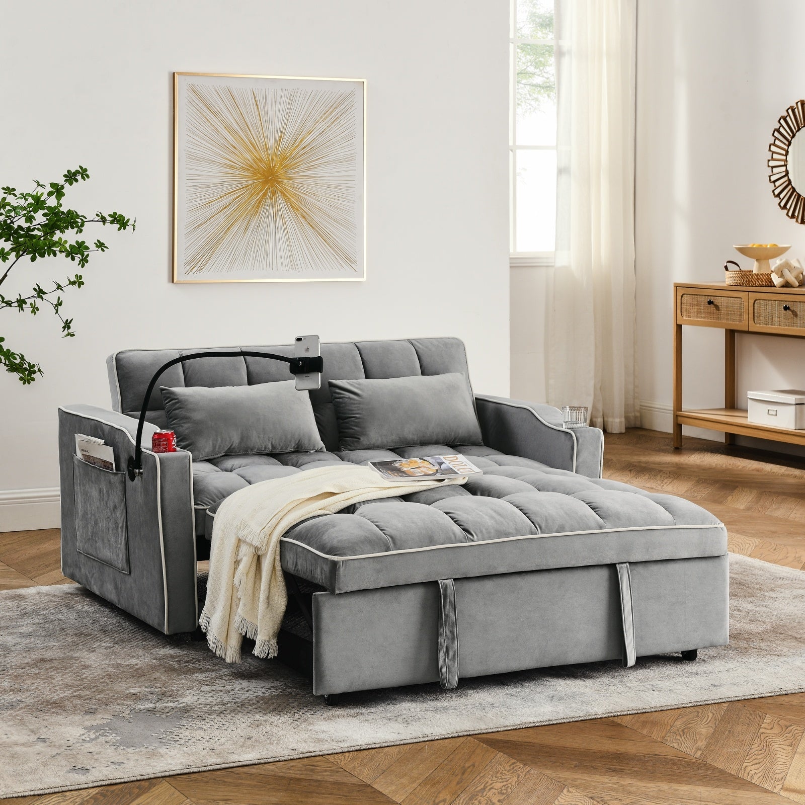 Gray sectional sofa in a living room setting with a rug and wall art.