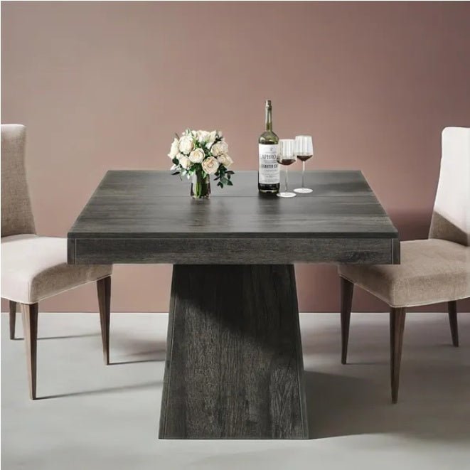 Dining table with chairs and a bottle of wine in a room with a pinkish-beige wall.