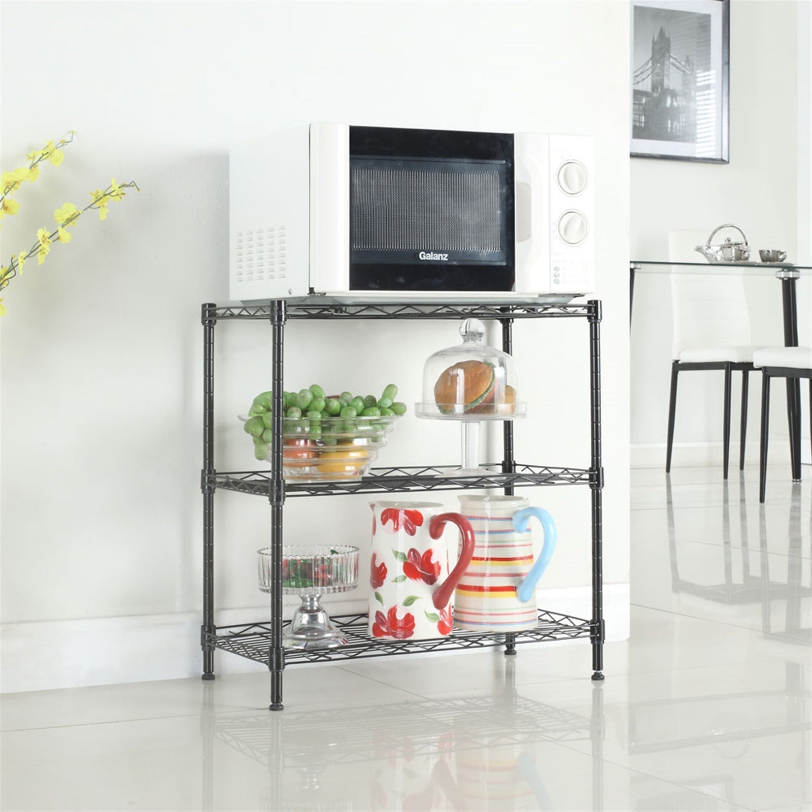Black metal shelving unit with a microwave and various items in a kitchen setting.