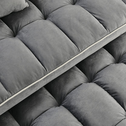 Close-up of a gray tufted sofa cushion with a visible brand logo.