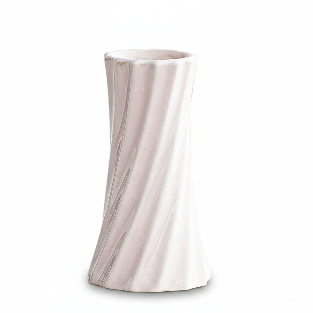 A pale blush pink ceramic vase with a flared rim and subtle vertical ribbed texture, shown on a clean white surface. Text in the upper left reads '6.