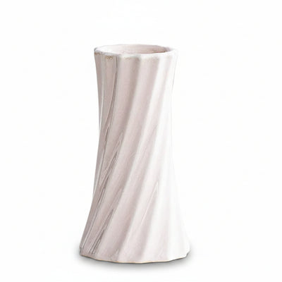 A pale blush pink ceramic vase with a flared rim and subtle vertical ribbed texture, shown on a clean white surface. Text in the upper left reads '6.