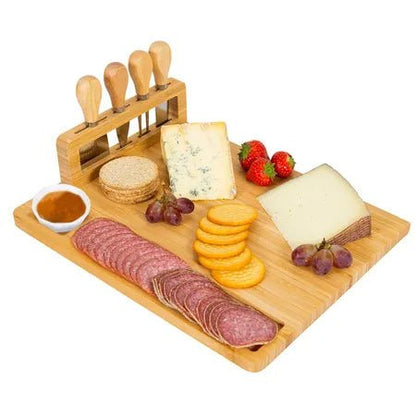 Wooden charcuterie board with sliced meats, cheeses, and fruits on a white background
