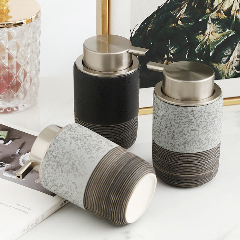 Three decorative jars with speckled design and metallic lids on a white surface.