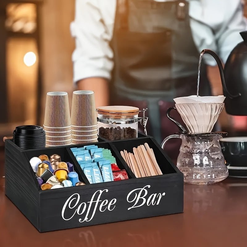 Coffee bar set with cups, coffee maker, and supplies on a wooden counter.