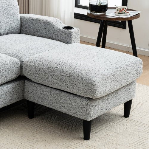 Gray textured sectional sofa in a living room setting with a small table and decor items.