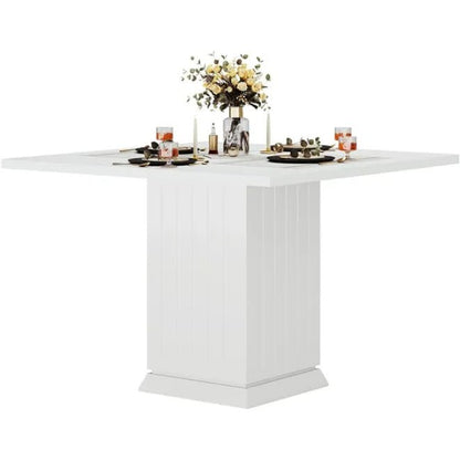 White dining table with a floral centerpiece on a white background