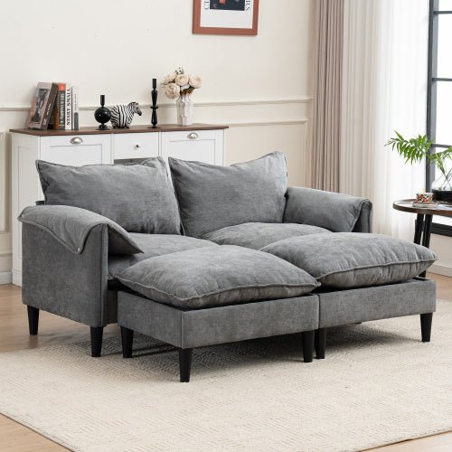 Gray sofa in a living room setting with a white wall and wooden floor.