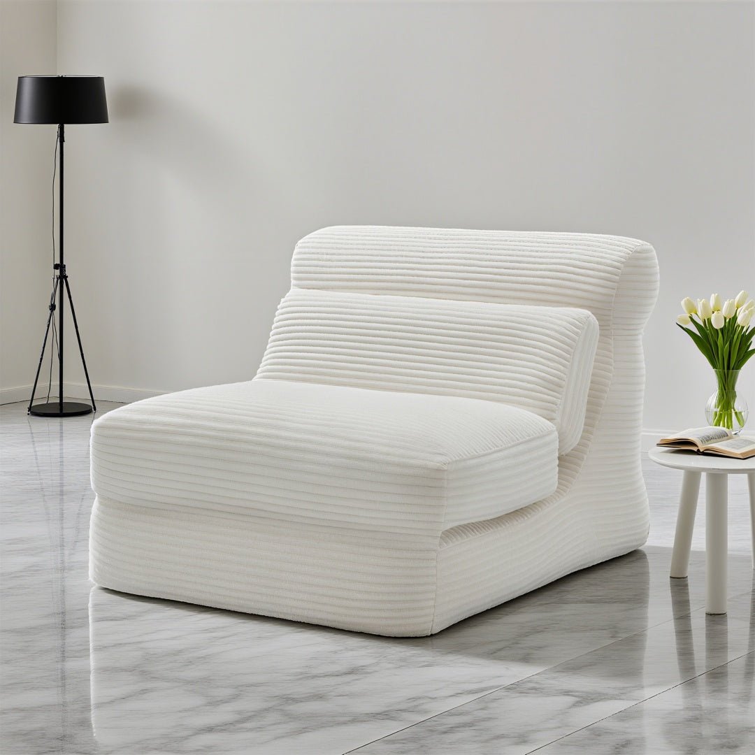 White ribbed armchair in a modern room with a lamp and small table.