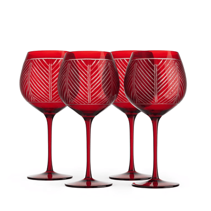 Four red wine glasses with geometric patterns on a white background