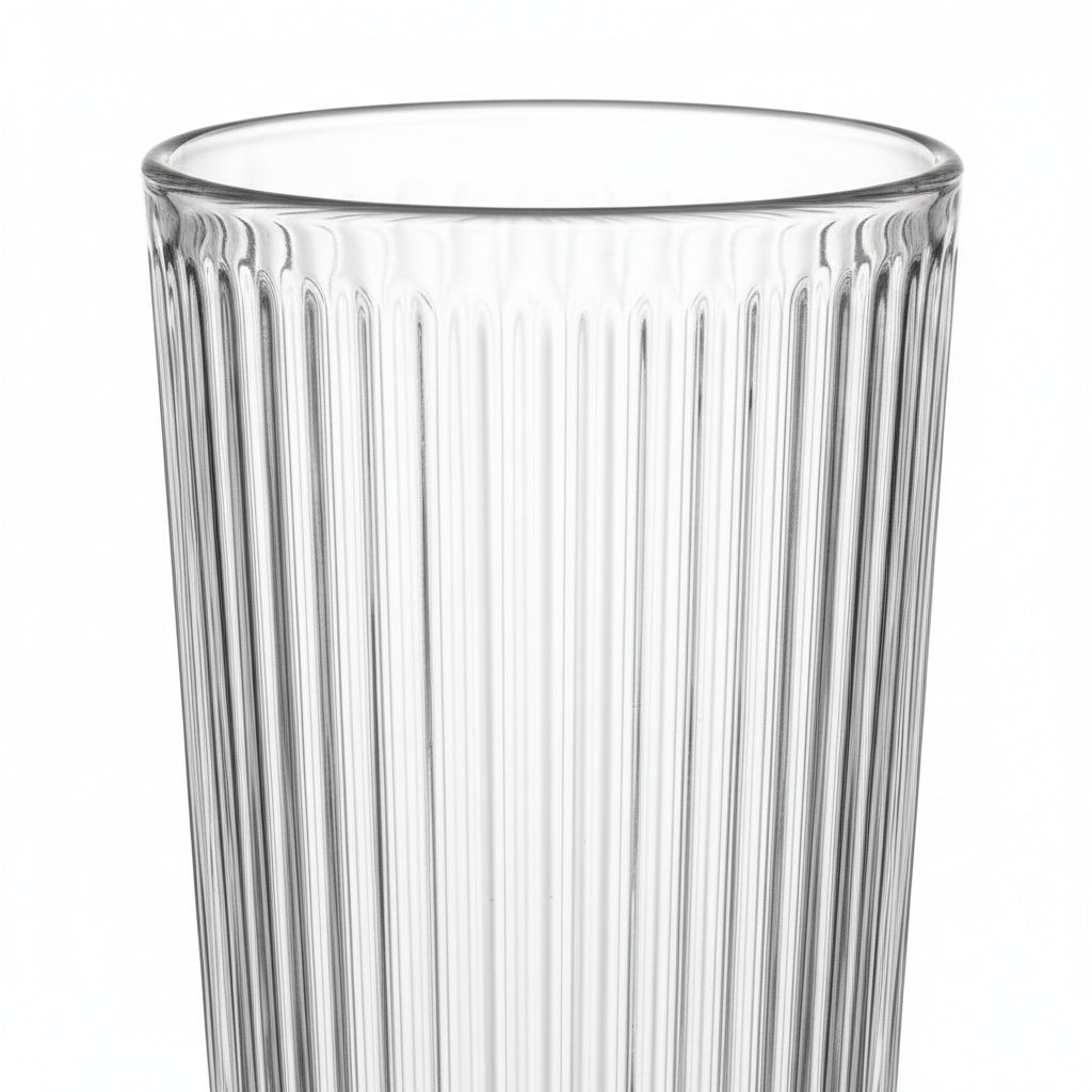 Clear glass tumbler with vertical ribbing on a white background