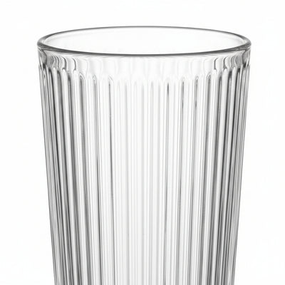 Clear glass tumbler with vertical ribbing on a white background