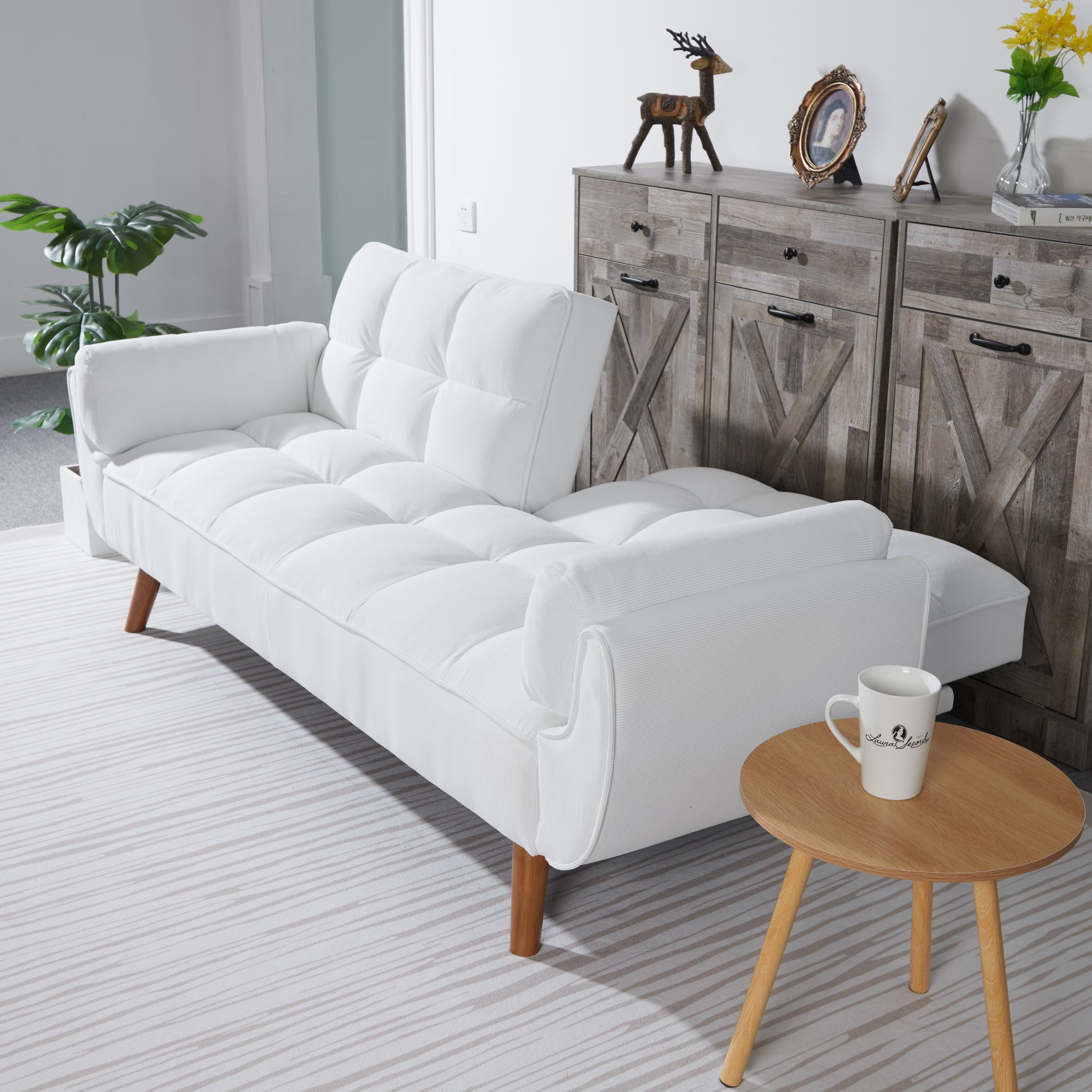White sectional sofa in a living room with a wooden side table and decorative items.