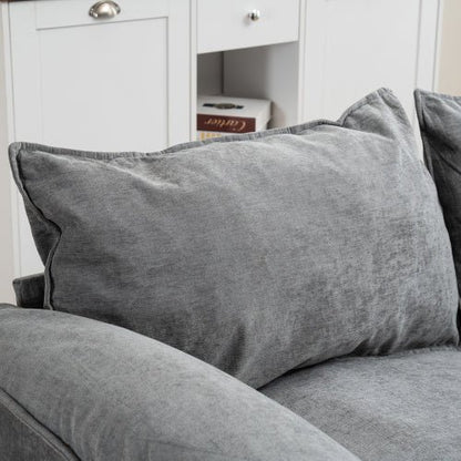 Gray cushion on a gray sofa with a white cabinet in the background