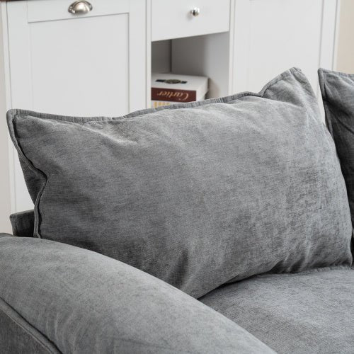 Gray cushion on a gray sofa with a white cabinet in the background