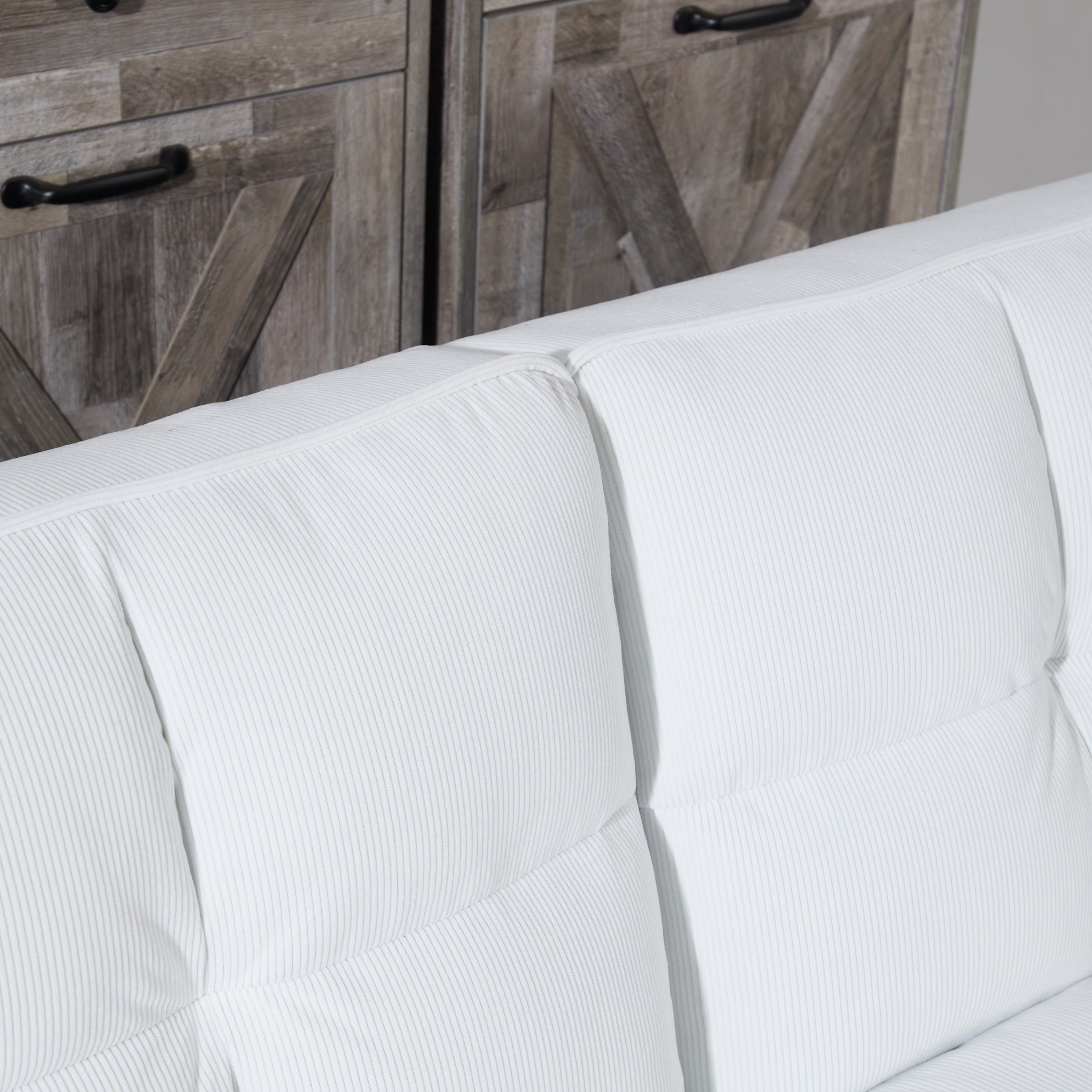 White sofa with wooden cabinets in the background