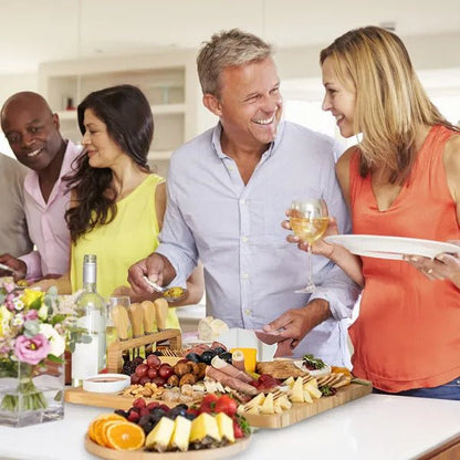 Group of people enjoying a meal together with a charcuterie board and wine glasses.
