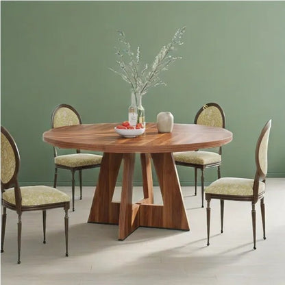 Dining table set with four chairs against a green wall