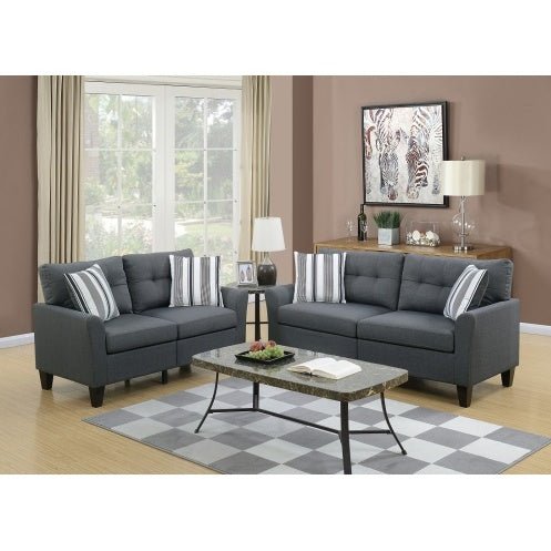Gray sofa set in a living room with a checkered rug and decorative items.
