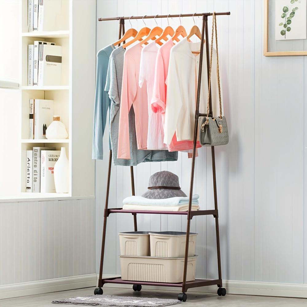 Clothing rack with clothes and bags in a room with shelves and a plant.