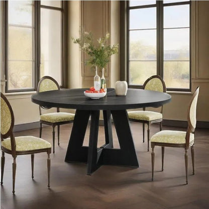 Dining room with a black round table and chairs in a well-lit room.
