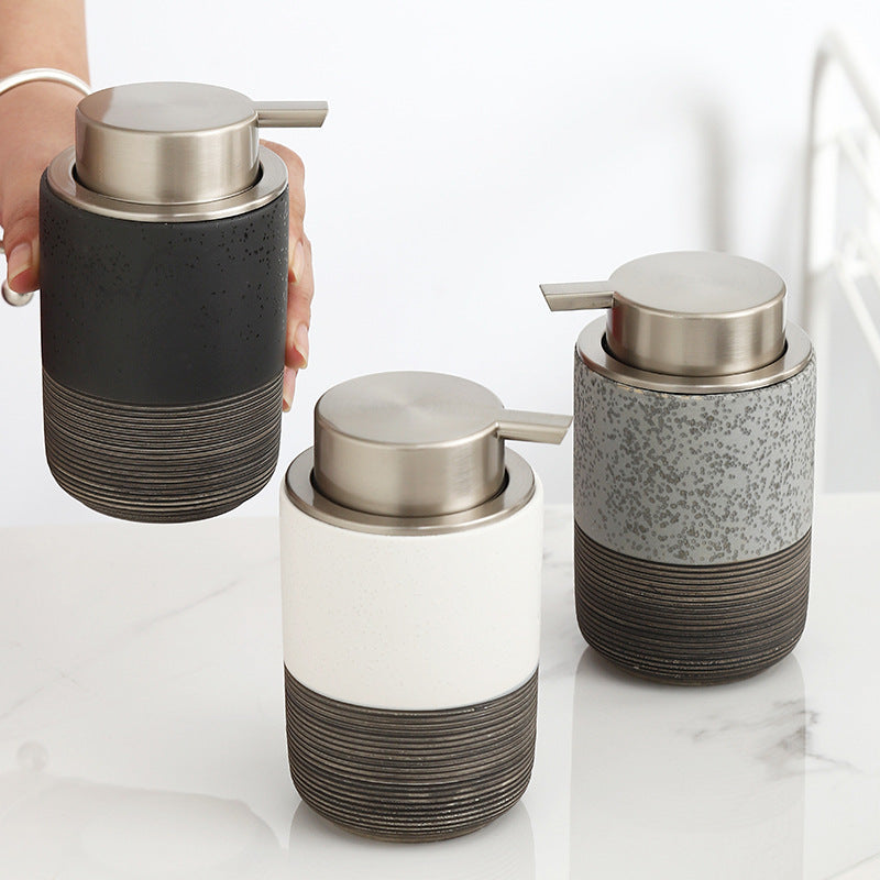 Three soap dispensers with textured design on a marble surface