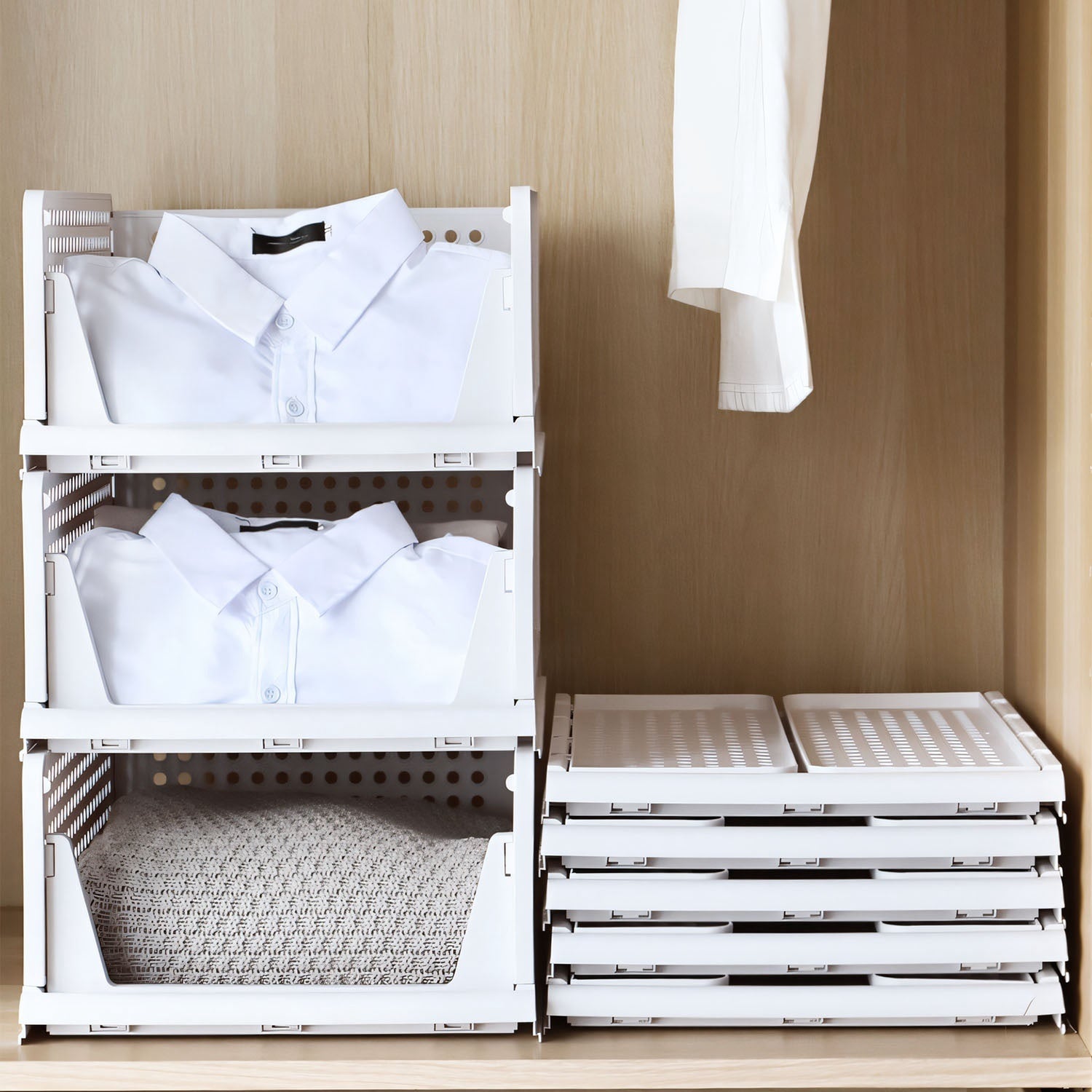 White storage crates with clothes inside, stacked on a wooden surface.