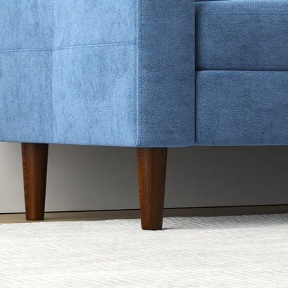 Close-up of a blue upholstered chair with wooden legs on a neutral background