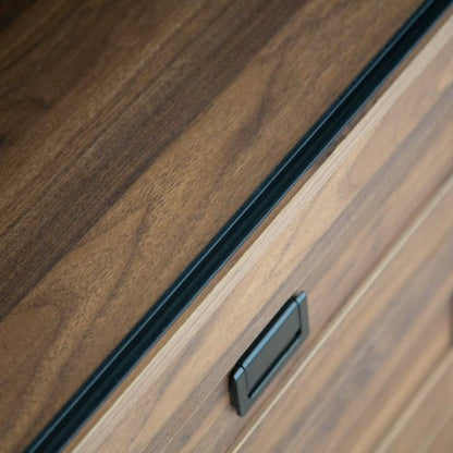 Close-up of a wooden cabinet with a black handle